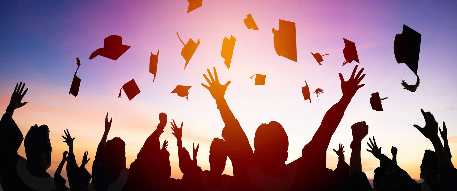 happy students throwing graduation caps in the Air
